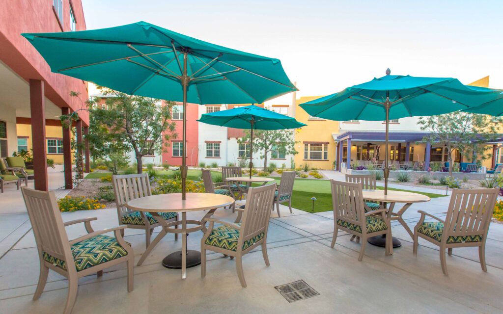Sage Desert Tucson AZ 2018 June -0815 - The Ranch Estates of Tucson The Ranch Estates of Tucson courtyard with beige tables and chairs and blue umbrellas.