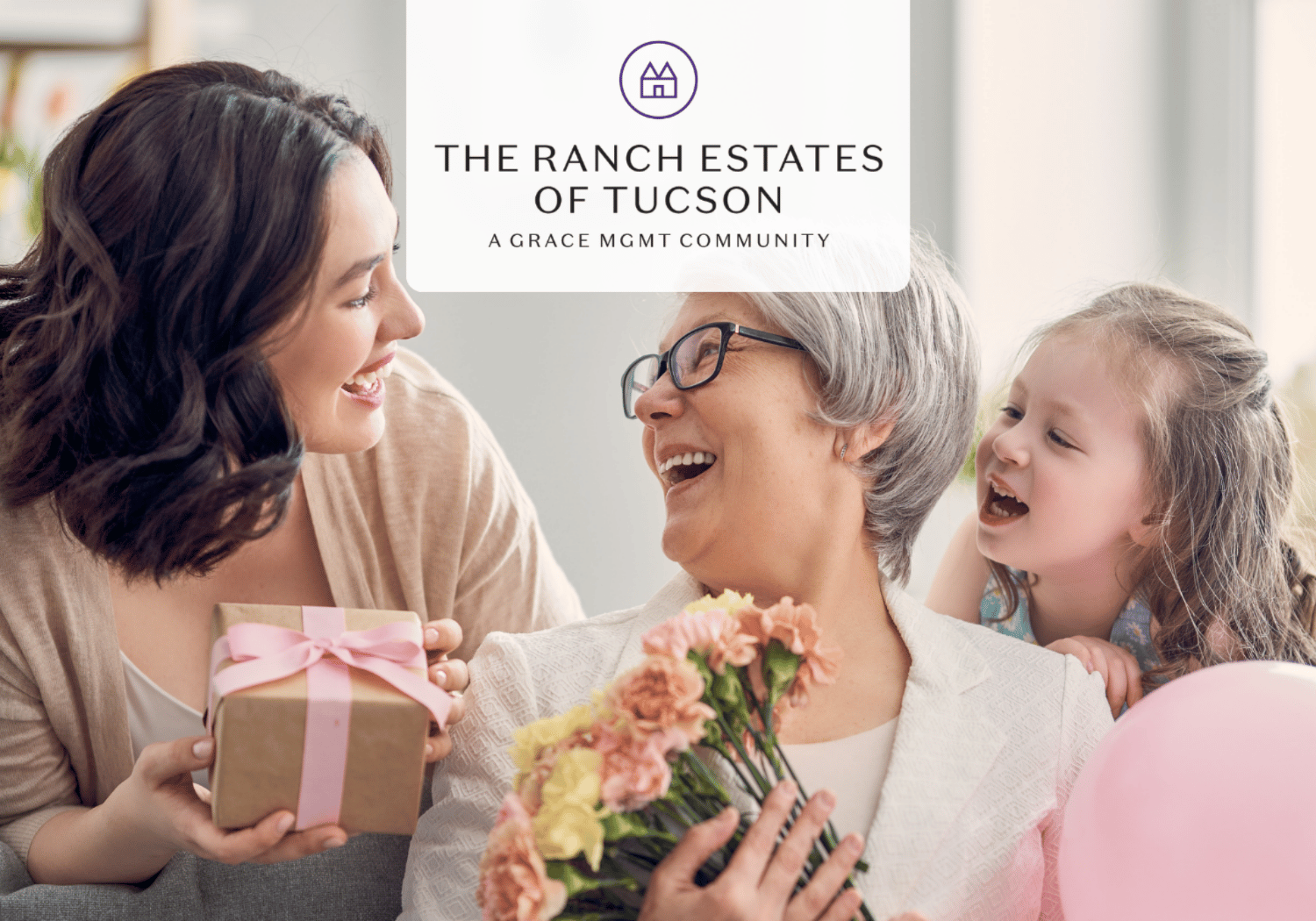 Three generations share a joyful moment: a younger woman offers a gift to an older woman holding flowers, with a smiling child in the background; branding reads 'The Ranch Estates of Tucson'.